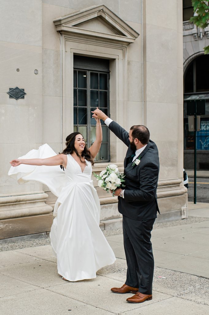 Groom spinning bride outside the church after their wedding ceremony.