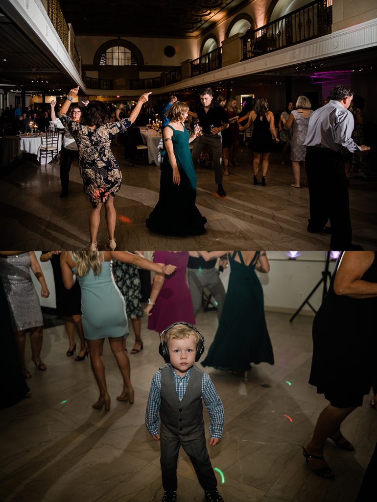 Guests dancing at a wedding reception, and small child with large headphones looking at the camera in the middle of the dance floor.