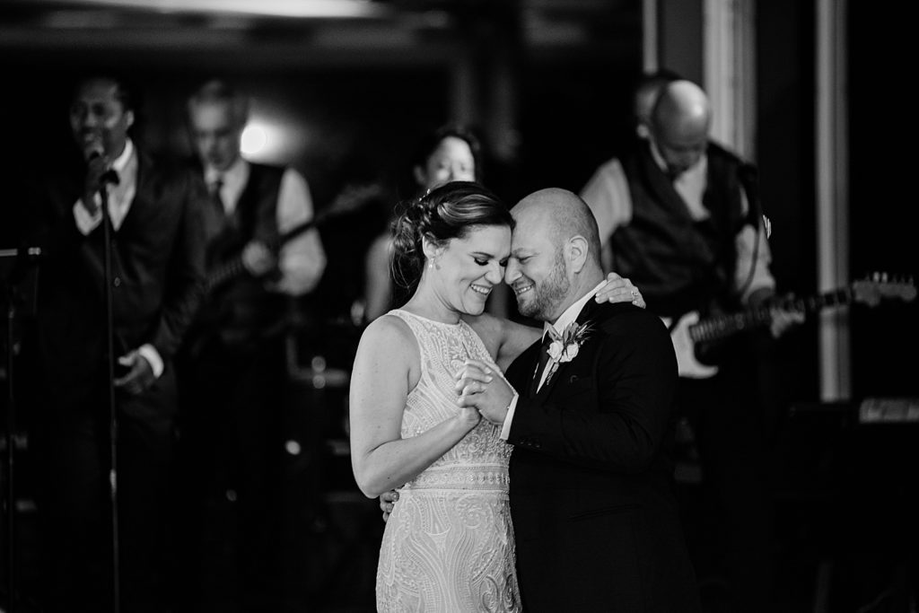 Black and white image of bride and groom dancing at their reception.