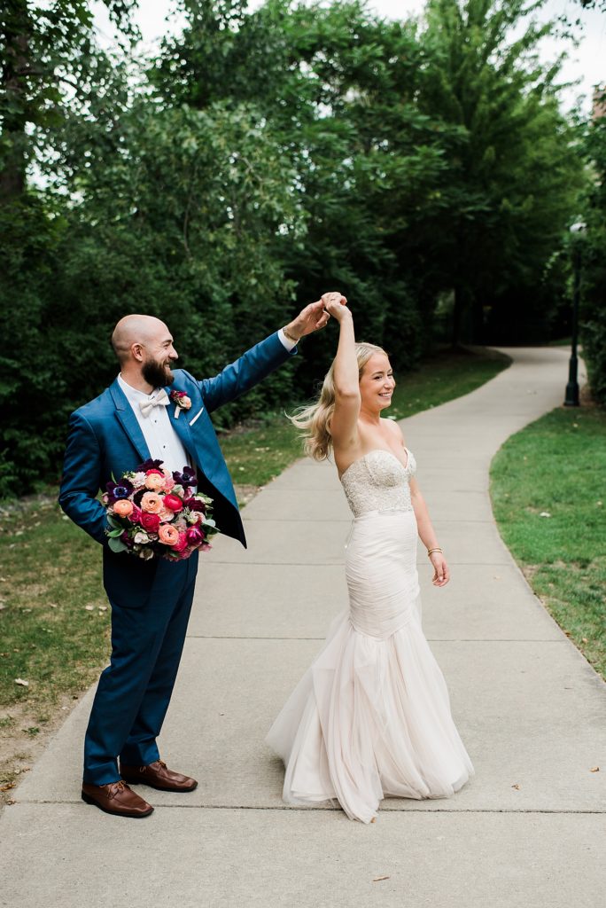 Bride and groom dancing on a sidewalk. 