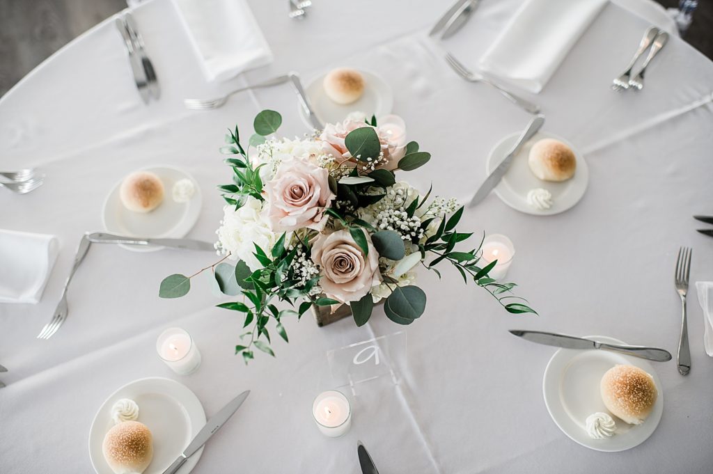 Image from above a table at a wedding reception with flowers in the middle. 