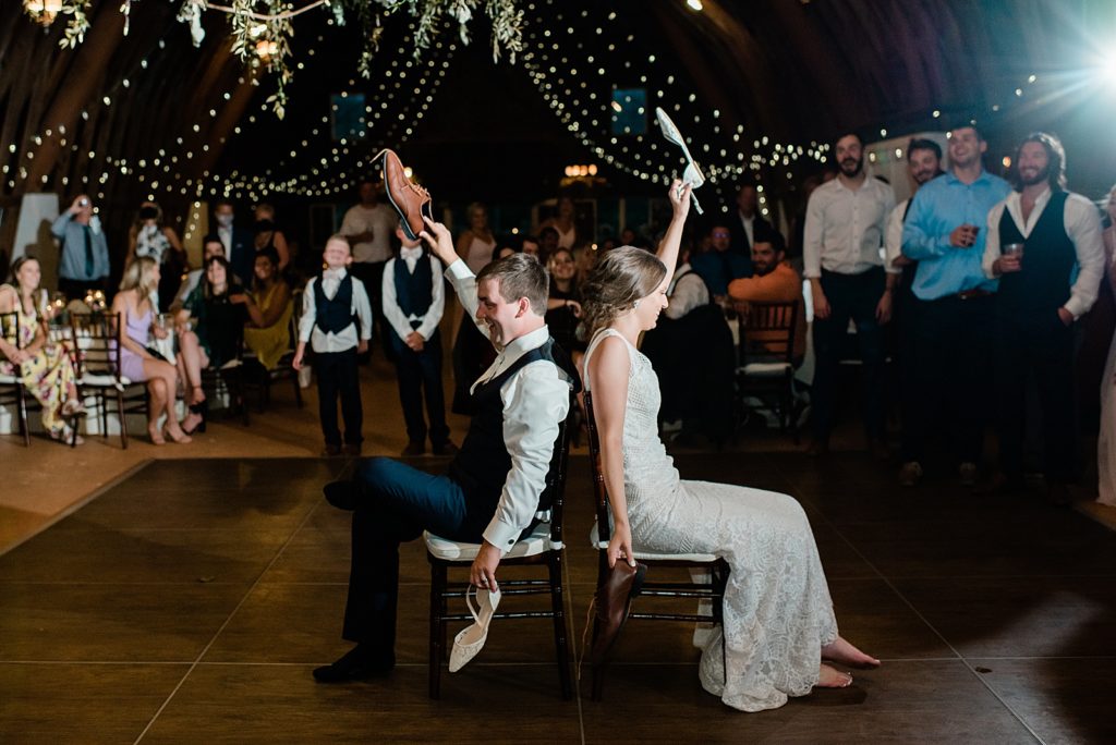 Bride and groom sitting back to back with shoes in the air. 