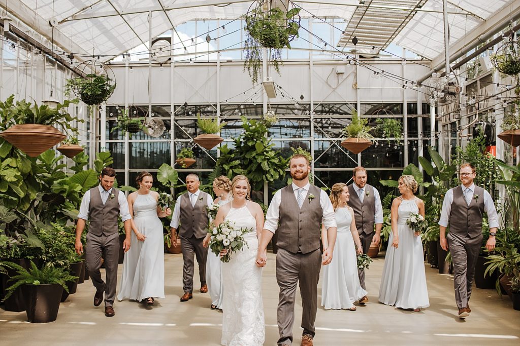 Large wedding party in pastel colors in a greenhouse at the Downtown Market in Grand Rapids.