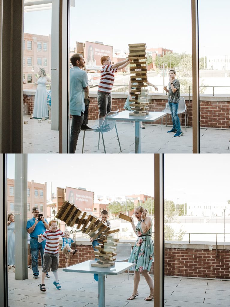 Guests playing with a massive Jenga tower at a wedding reception.