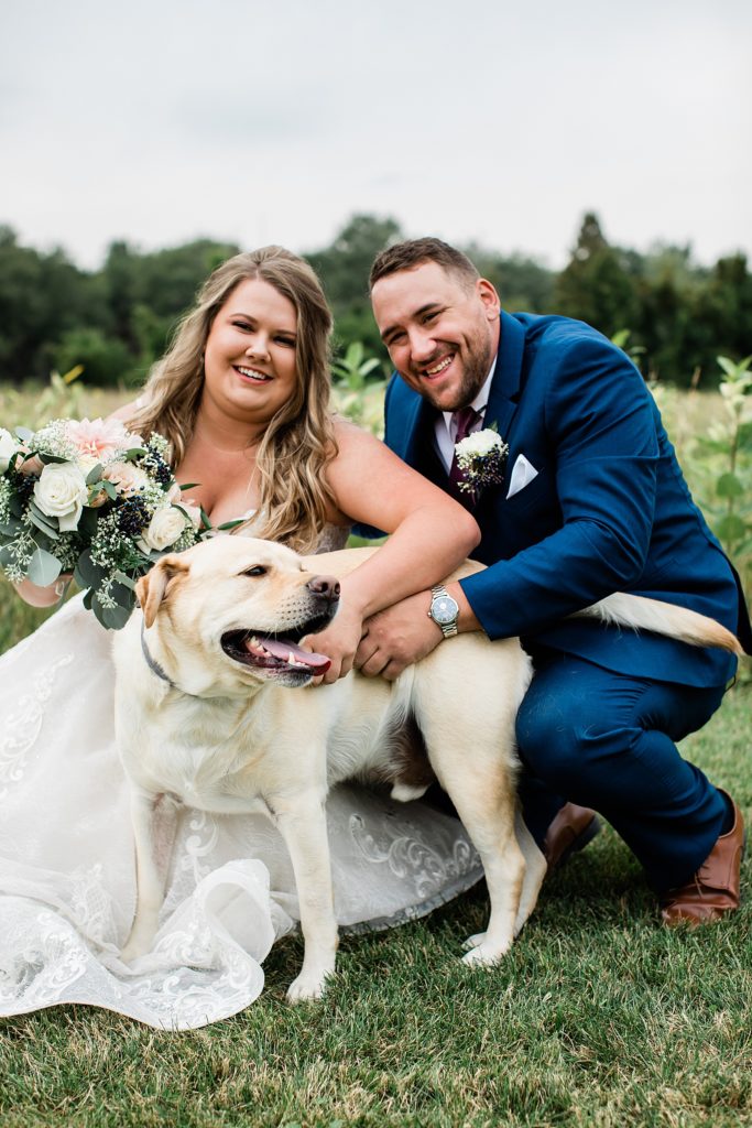 Bride and groom snuggling their dog for their wedding portraits. 