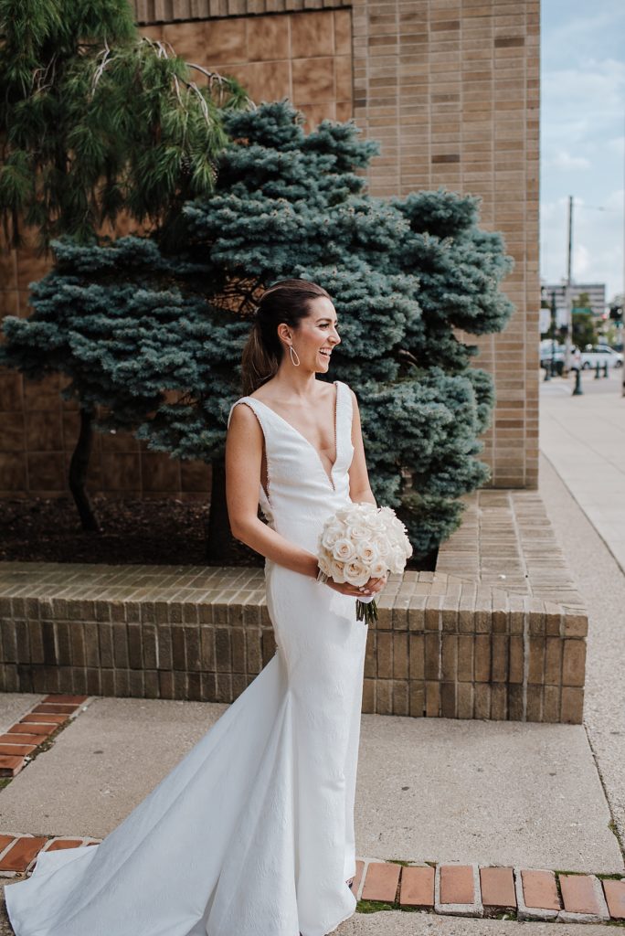 Bride standing in front of a city building after her wedding. 