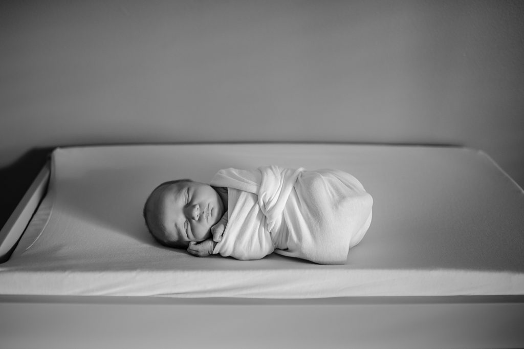 Tiny baby on a diaper changing pad for her Michigan Lifestyle Newborn session.