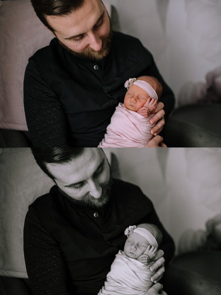 New dad holding his baby girl in a pink wrap and floral headband for Michigan in-home photo shoot. 
