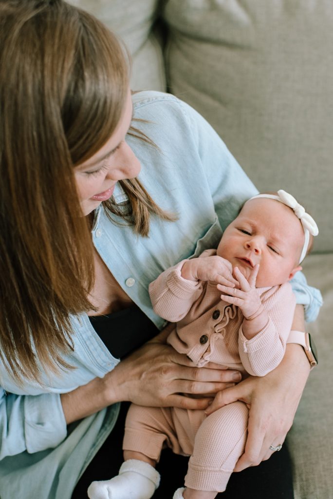 Baby in mom's arms for Michigan newborn photo shoot. 