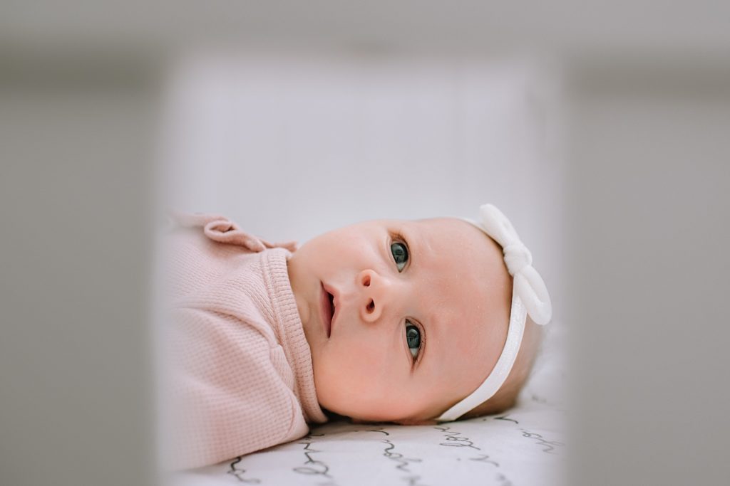 New baby lying in a crib for her newborn photo shoot.