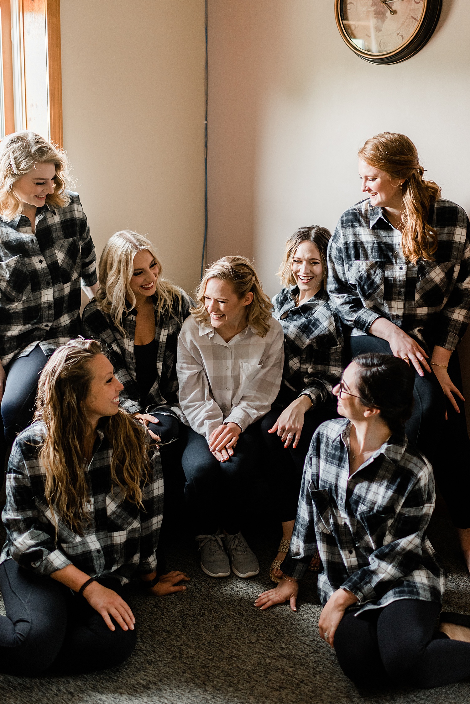 bride and bridesmaids share fun moment before ceremony in getting ready flannels
