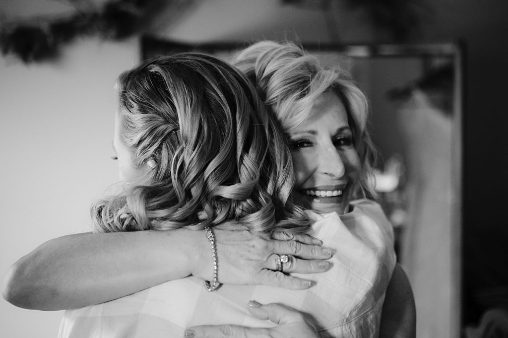 mother of bride and bride share a hug before heading out to the ceremony location 
