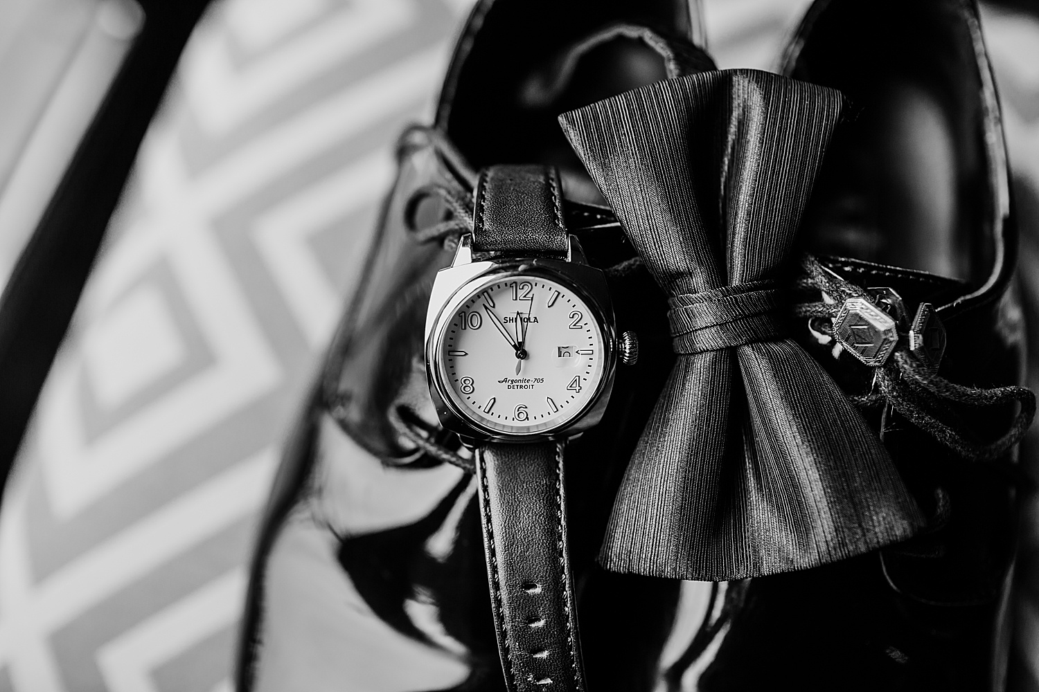 groom's watch and bowtie with dress shoes on a chair while groom is getting ready at the Inn at St. Johns