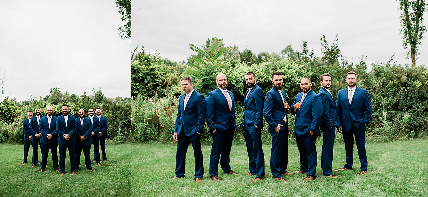 Groom and groomsman in navy blue suits with brown dress shoes and a blush colored tie