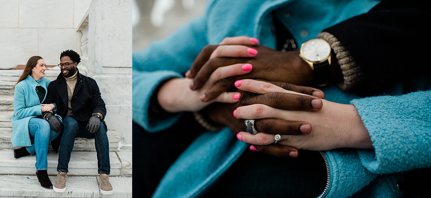 Engaged couple shows off wedding ring while sitting on steps during city photo shoot