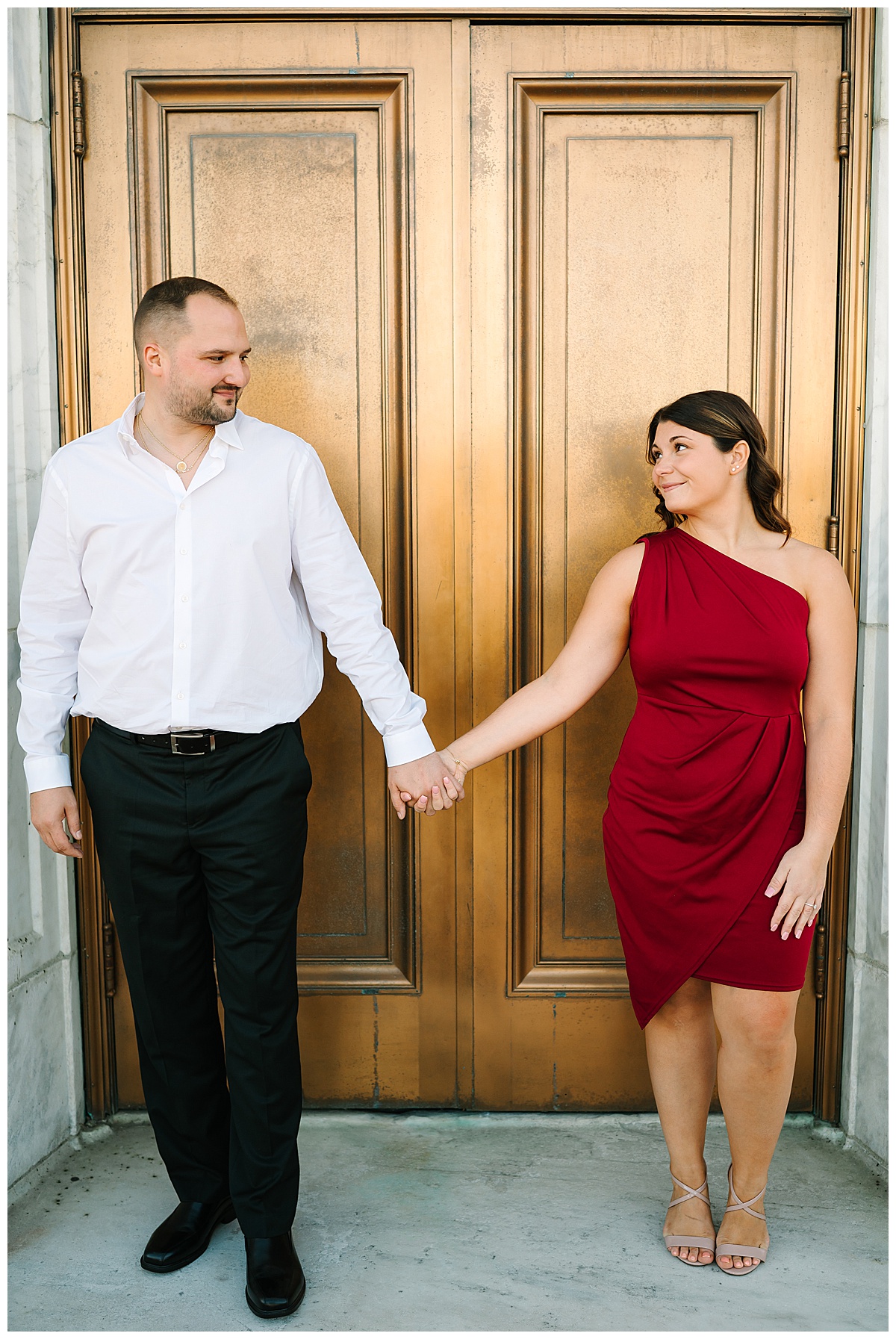 Holding hands, couple looks at each other for Michigan Wedding Photographer