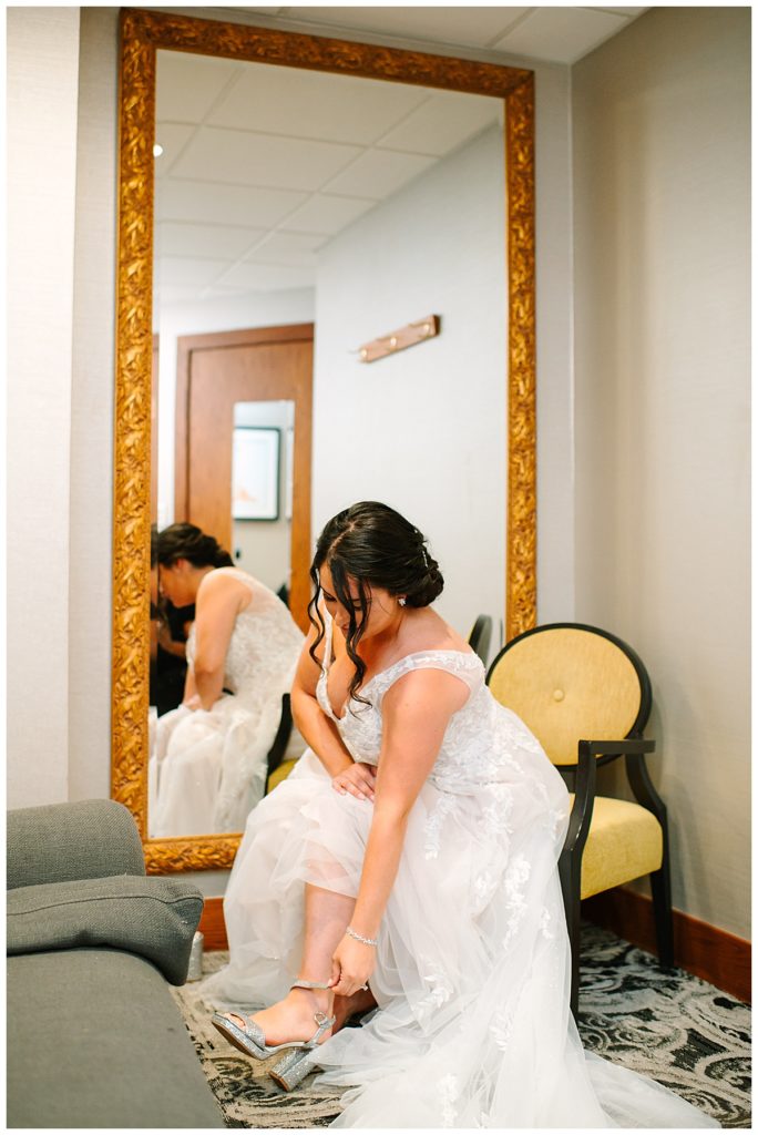 Bride putting on her shoes for Michigan Wedding Photographer