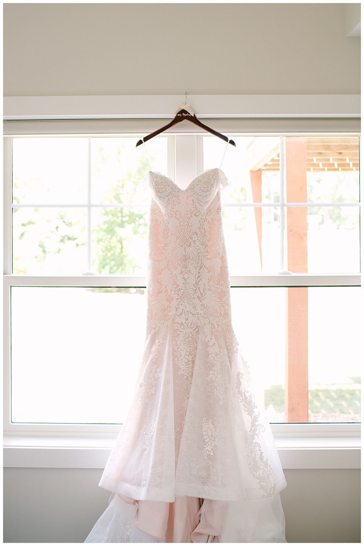 Bridal gown in front of window by Brittany Emerson Photography