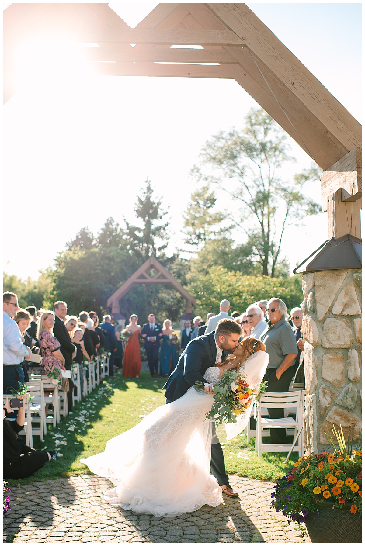 Bride and groom kiss at the end of the aisle for Michigan Wedding Photographer