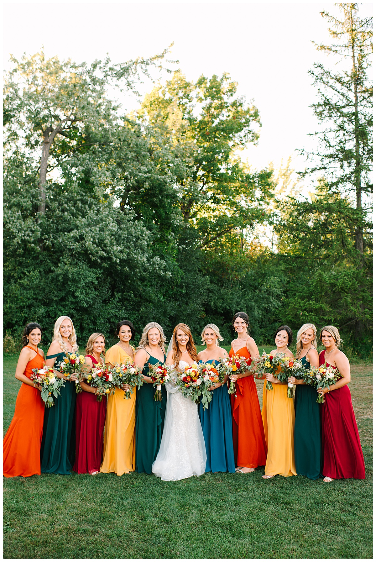 Bride is surrounded by bridesmaids in beautiful colorful dresses for Glen Oaks wedding